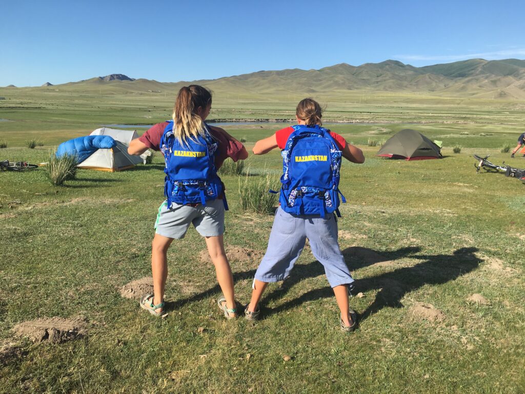 Sporting Kazakhstan backpacks in camp