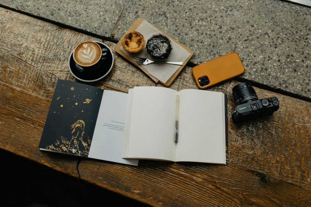 A journal, coffee, camera, phone and muffins to practice mindfulness