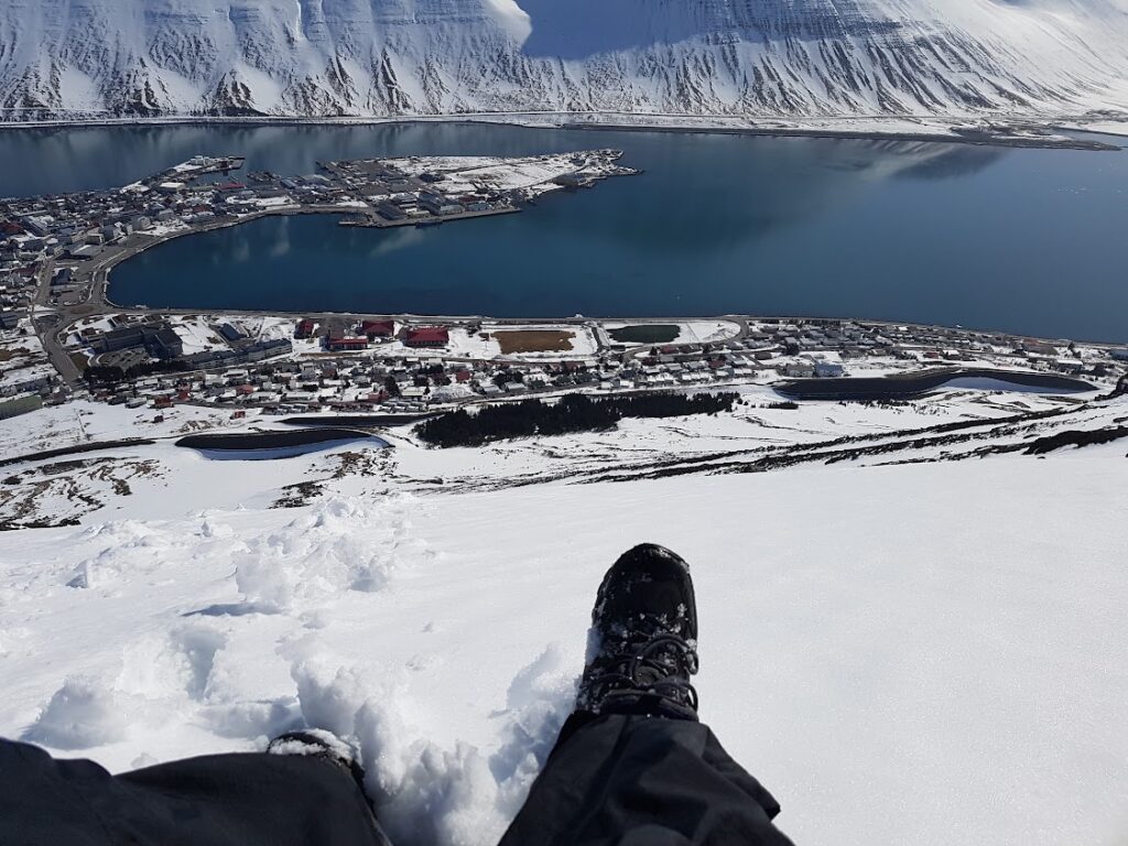 Looking down a snowy mountain while winter hiking in Westfjords, Iceland 