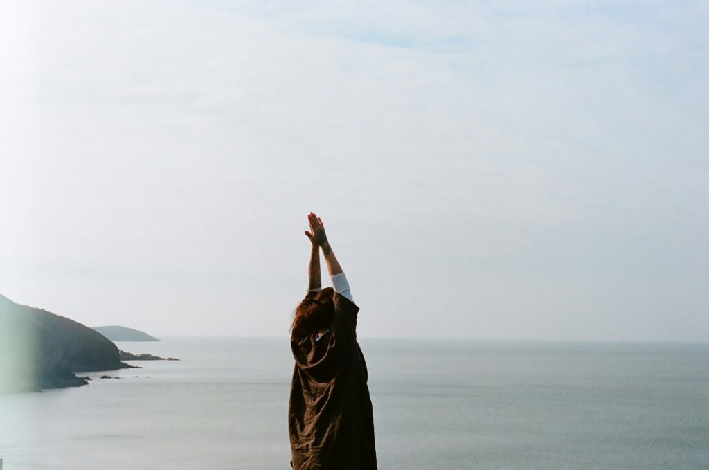 A woman stretching by the ocean 