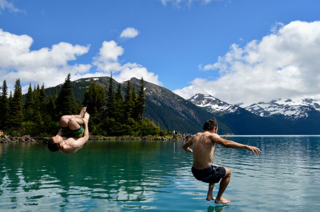 Two men jumping into the cold water to swim