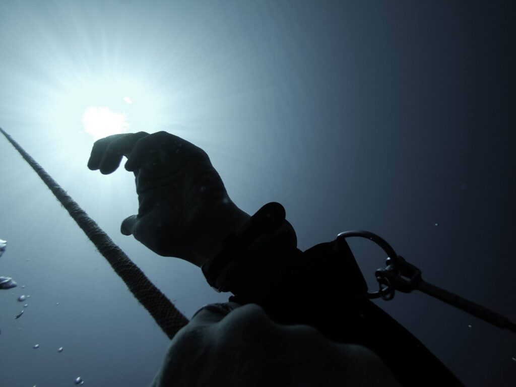 Hands on a rope underwater while freediving