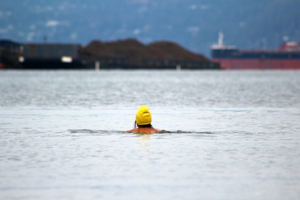 A lady with yellow cap cold water swimming