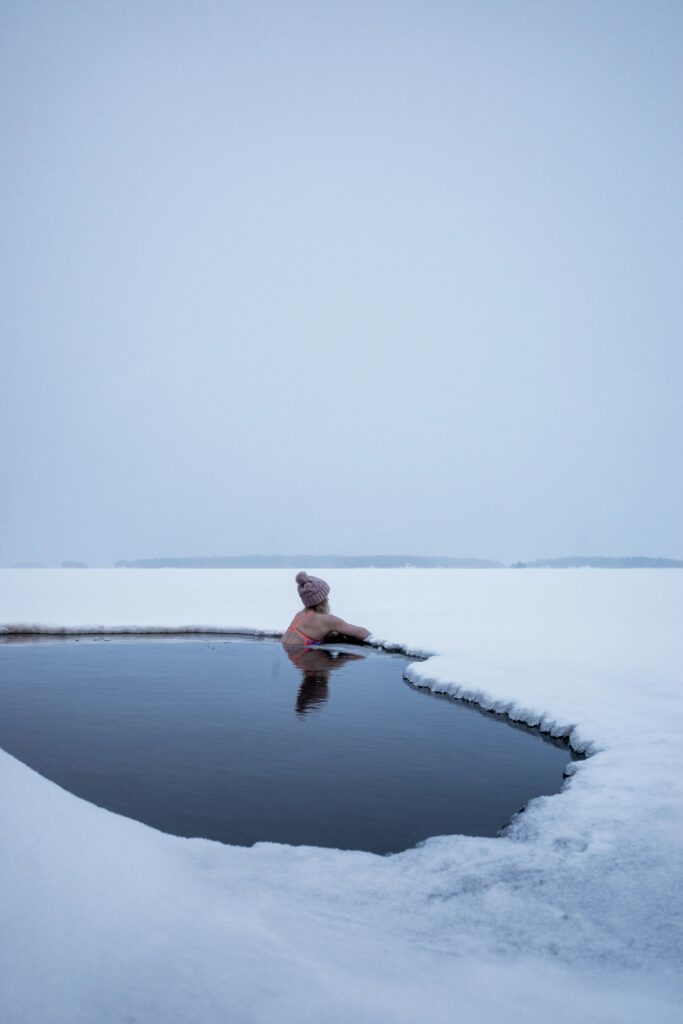 A women taking a cold plunge in a frozen lake