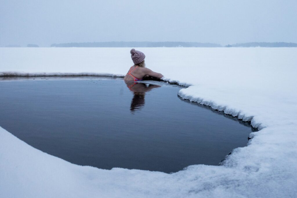 A women taking a cold plunge in a frozen lake