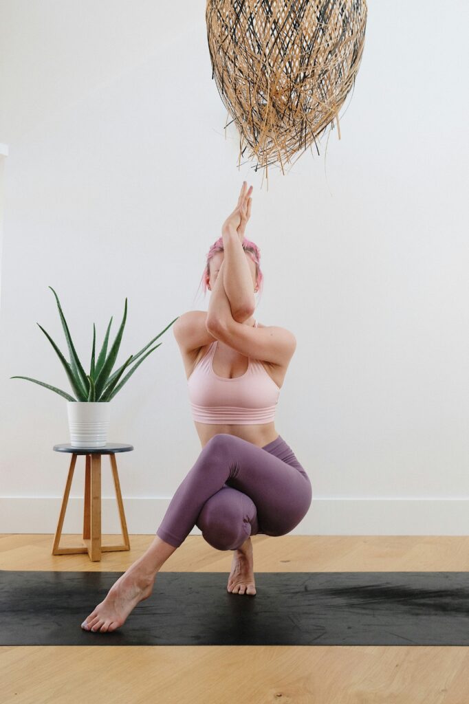 A woman doing breathwork and movement through yoga