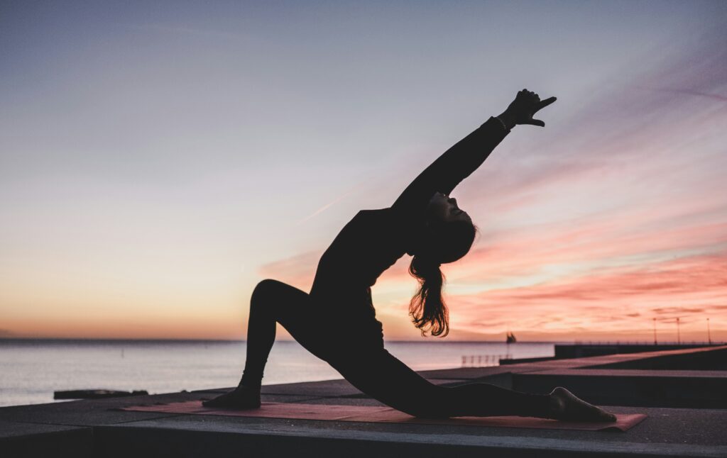 a yoga pose doing breathwork at the beach