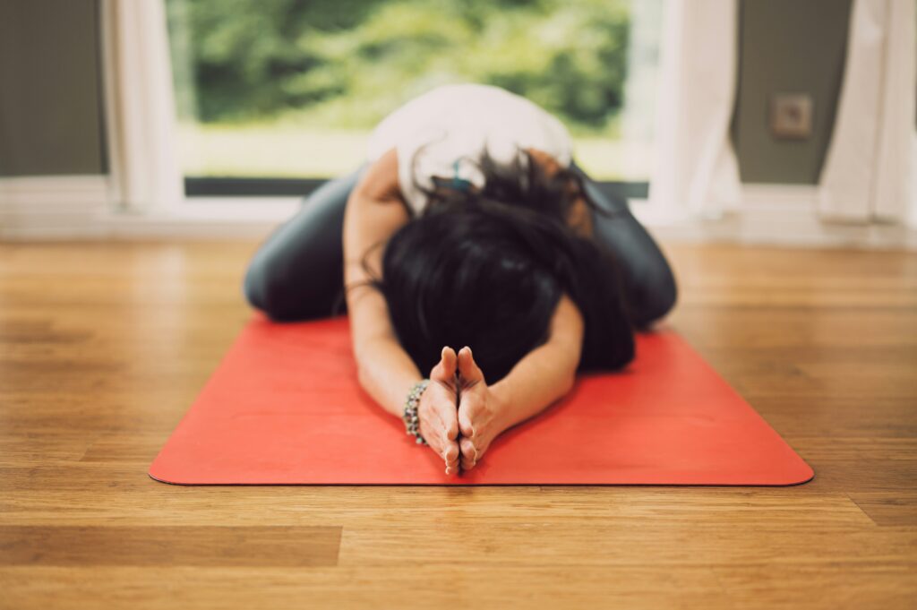 lady on yoga mat in childs pose