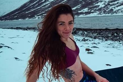 Elaina with a mermaid tail in the snow practicing cold therapy