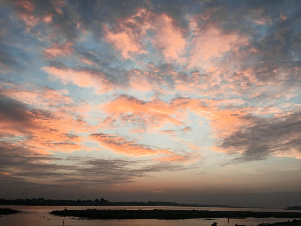 sunset with pink clouds over looking the ocean