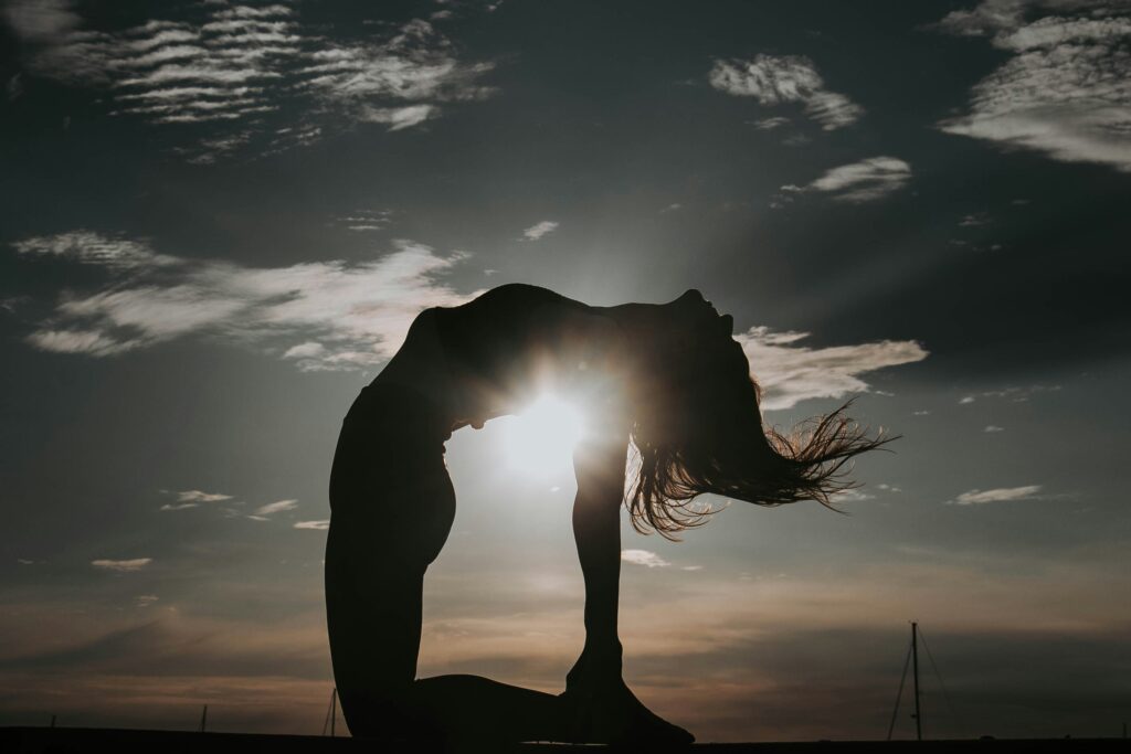 a woman doing a backbend in the sunshine 